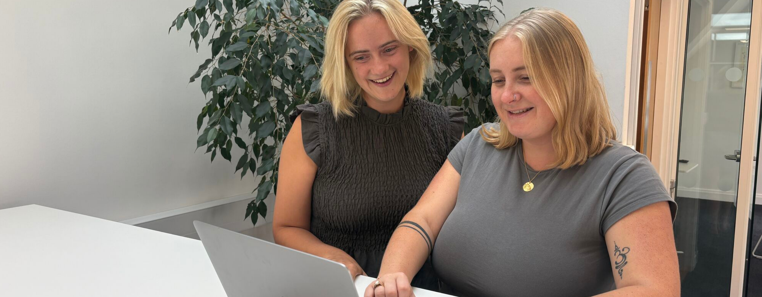 Chloe C and Molly looking at a laptop on a desk